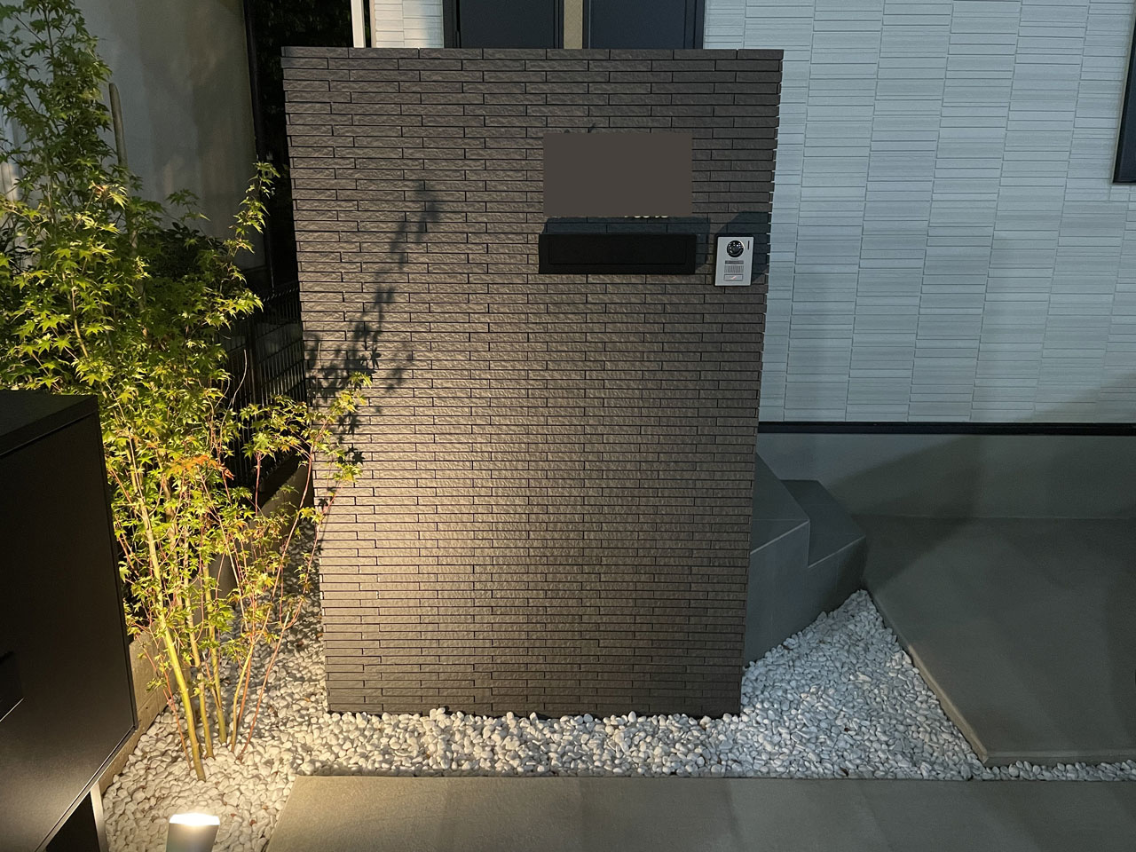 東京都世田谷区のY様邸/夜間にライトアップされた植栽と門柱の写真
