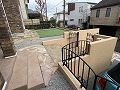 車庫の上には背の低い黒いアイアンフェンスを使用し、門扉と統一感を出した外構の施工例