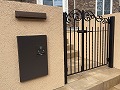 川崎市でベージュ系カラーの門柱・門袖に黒い鋳物のアイアン門扉を取り付けた施工画像