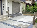 コンクリート打ちをした車庫には正方形の黒色系タイルを貼り付け、車庫の横には化粧ブロックで階段付きのステップを施工した画像/室内から外へ出やすくなりました