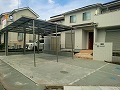 敷地と駐車場の境には門柱と塀、フェンスで区切りをつけました/ワイドタイプのカーポート設置と車庫コンクリート打ちをした外構工事の施工例