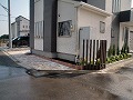 敷地のコーナーに茶色い角材を9本建て、オシャレ感をアップさせたオープン外構の施工例