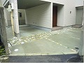 ビルトインタイプの車庫をコンクリート打ちし、ところごころにピンコロでデザイン性をもたせた外構の画像